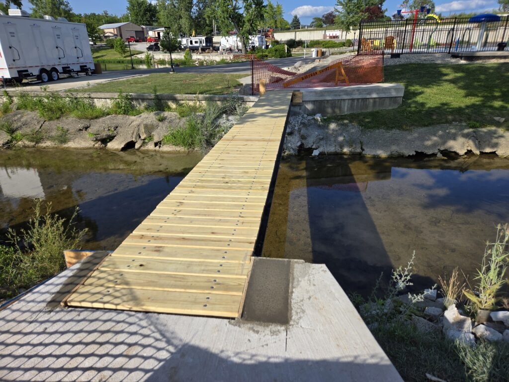 Steel and treated wood bridges — bridge 2 decking installed over water with safety fencing still up — Findlay, Ohio