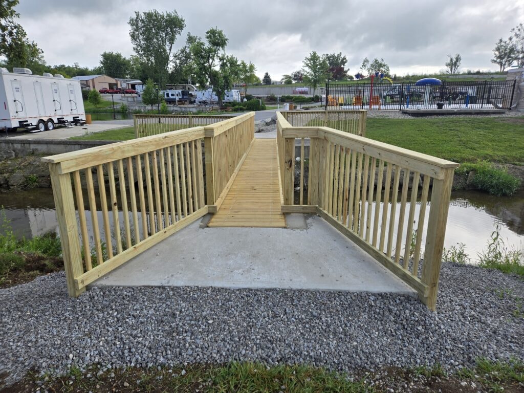 Steel and treated wood bridges — bridge 3 completed with Glacier Hill Lakes sign and golf cart crossing — Findlay, Ohio